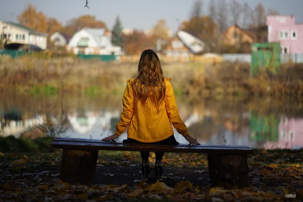 Personne assise en pleine nature, face à un étang, représentant la contemplation et la libération progressive liée au travail de deuil